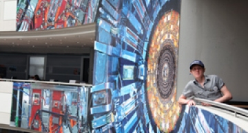 Marcus posing with the CMS poster in Building 40. Photo: Michael Hoch